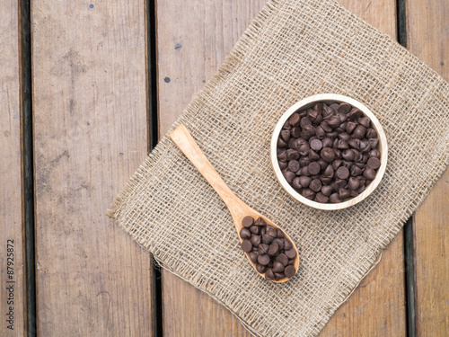 Chocolate chips in wooden spoon and bowl