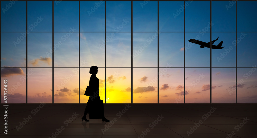 Business woman walking alone silhouette in the airport Business woman walking alone silhouette in the airport