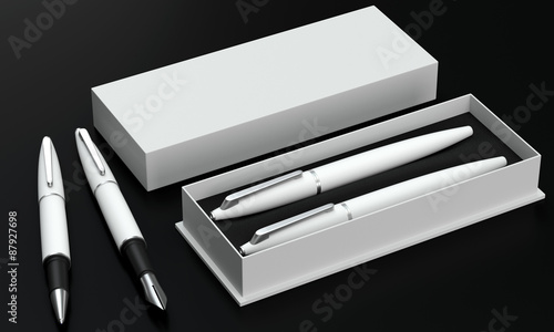 Foto Writing set. Ball pen and ink pen in a box on a black background