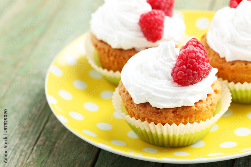 Raspberry cupcakes on green wooden background