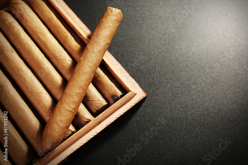 Tableau sur toile Collection of cigars in humidor on black table, closeup