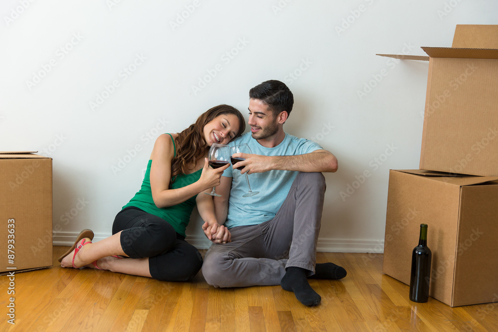 Lovers rejoice and are happy about their new life house sitting on the floor with wine Lovers rejoice and are happy about their new life house sitting on the floor with wine