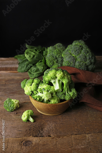 Fresh broccoli with spinach in bowl on dark background