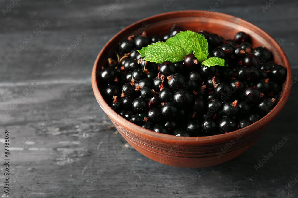 Ripe blackcurrant in bowl on wooden background Ripe blackcurrant in bowl on wooden background