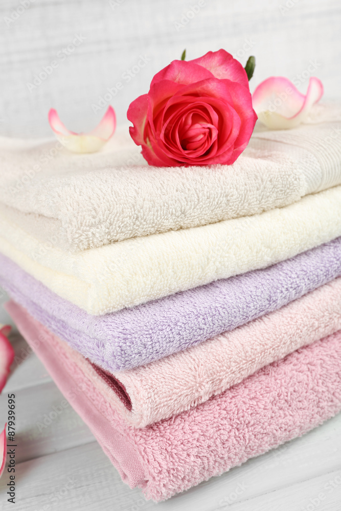 Stack of colorful towels on light wooden background Stack of colorful towels on light wooden background