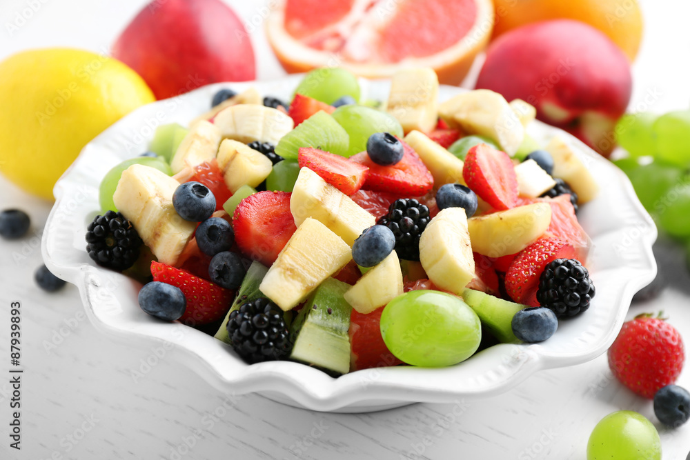 Fresh fruit salad on white wooden table Fresh fruit salad on white wooden table