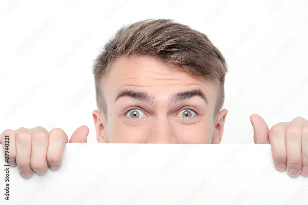 Curious man emerging from white board Curious man emerging from white board