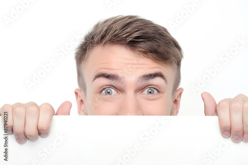 Canvas Print Curious man emerging from white board