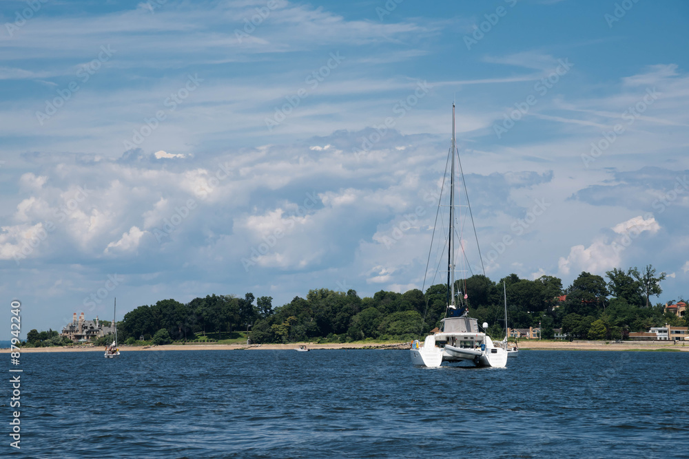 Luxury white catamaran anchored by the shore Luxury white catamaran anchored by the shore