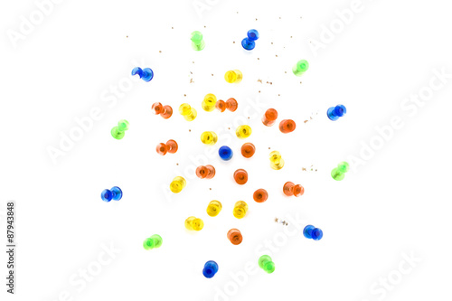 Colourful mass of stationery pins, holes on background paper