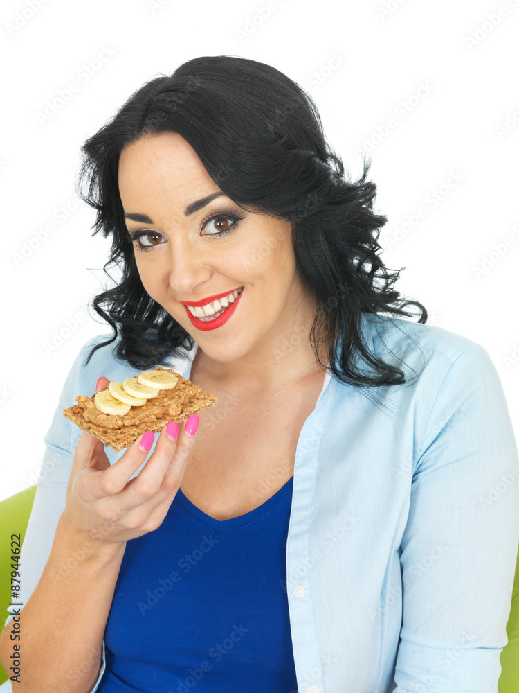 Young Woman Eating a Cracker with Peanut Butter and Sliced Banana Young Woman Eating a Cracker with Peanut Butter and Sliced Banana