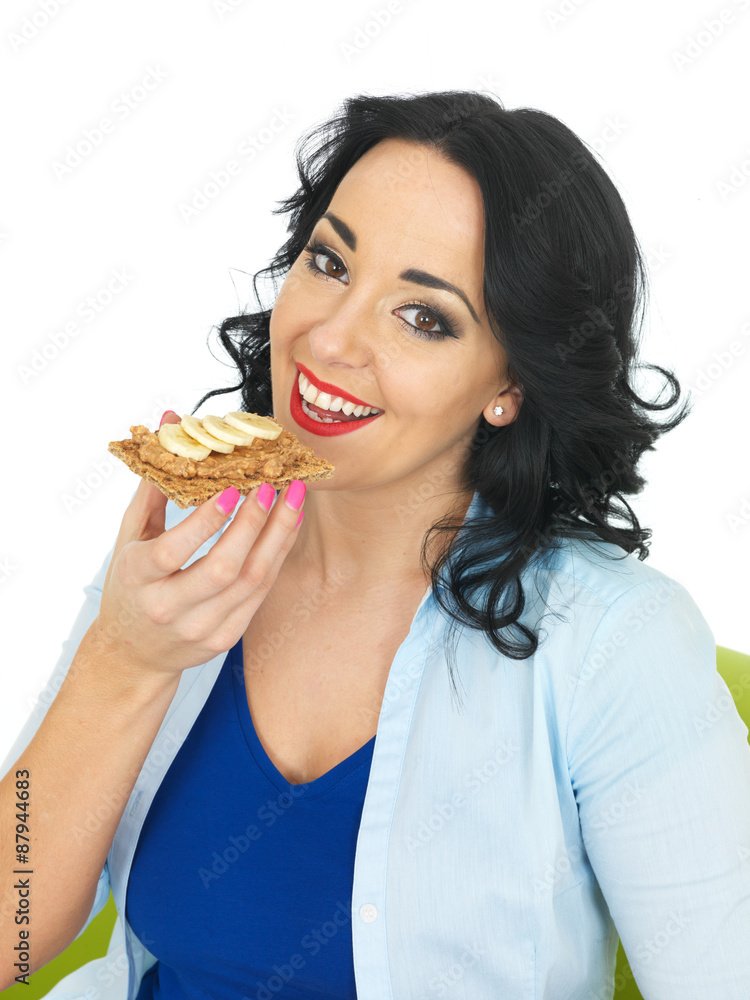 Young Woman Eating a Cracker with Peanut Butter and Sliced Banana Young Woman Eating a Cracker with Peanut Butter and Sliced Banana