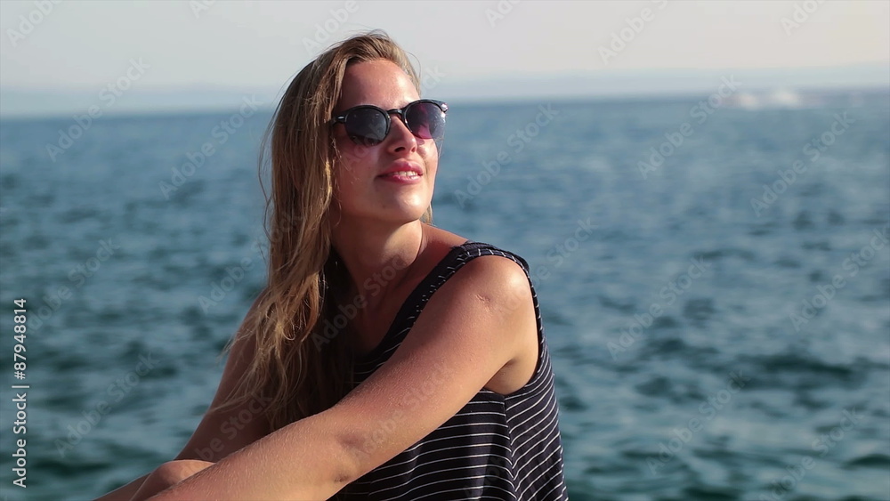 Pretty woman standing on the cliff and enjoying the waves Pretty woman standing on the cliff and enjoying the waves
