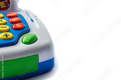 Part of toy cash register is with the green button of cash. Isolated on white.