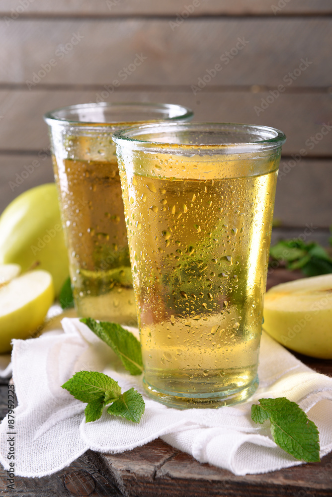 Wet glasses of apple juice on wooden background Wet glasses of apple juice on wooden background