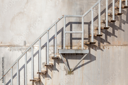 The stairway on exterior of refinery industrial storage tank.