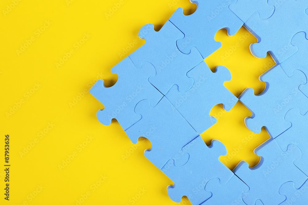 Fototapeta premium Puzzle pieces on yellow background