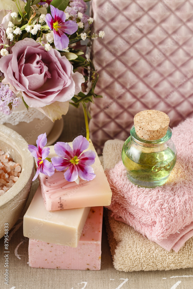 Bottle of essential oil, soft towels and bars of natural handmad Bottle of essential oil, soft towels and bars of natural handmad