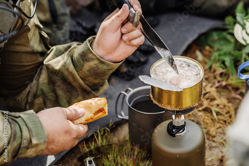 rangers are heated food on the fire and eat in the forest