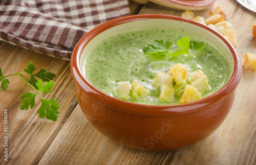 Creamy soup with  croutons on  wooden table.