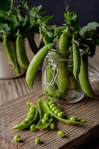 Ripe Green peas on wooden table.