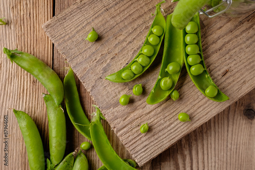 Ripe Green peas on wooden table.