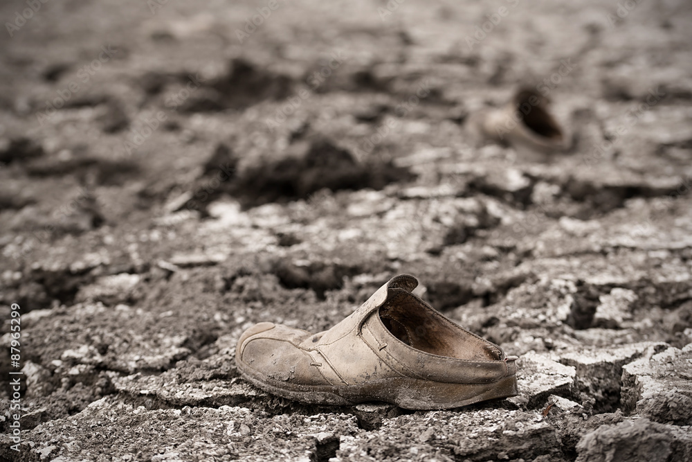 Abandoned shoe on dry ground, dramatic view Abandoned shoe on dry ground, dramatic view