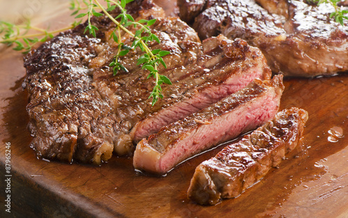 Fotografie Beef steaks on a  wooden board.