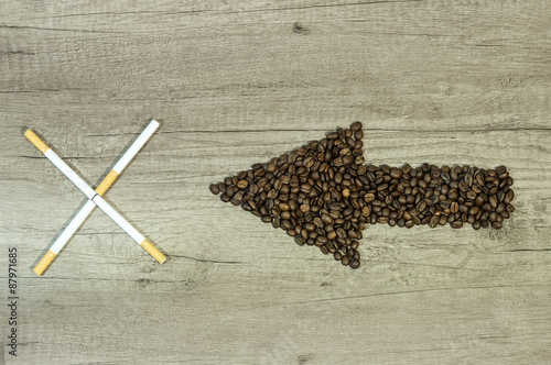 Arrow from the coffee beans with a four cigar on wooden backgrou