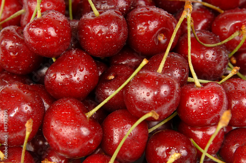 Background of ripe sweet cherry with drops and splashes water