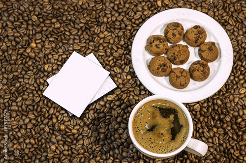 Coffee bean background with cup of fresh hot coffee and plate fu