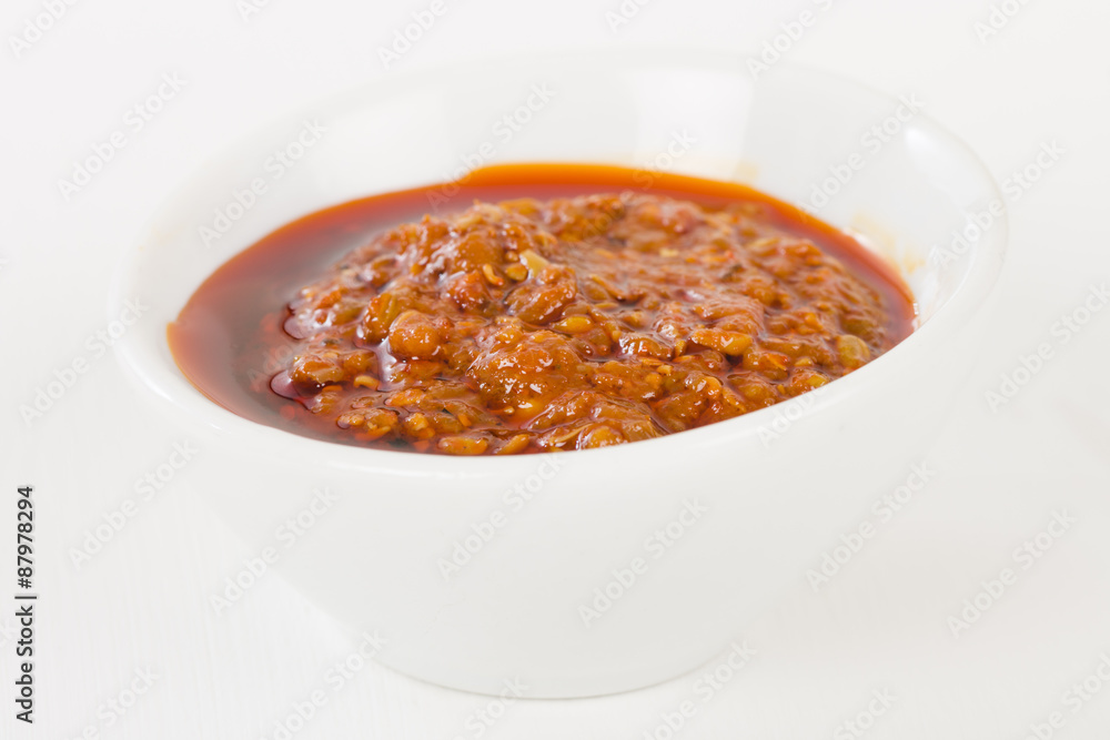 Chilli Dip - Naga chilli sauce in a white bowl on a white background. Chilli Dip - Naga chilli sauce in a white bowl on a white background.