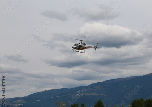 light helicopter flies in the sky and carries tourists