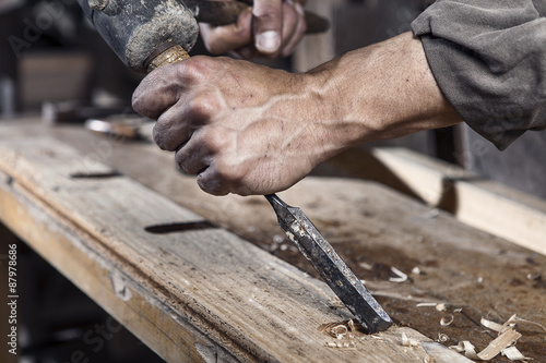Hands of carpenter with chisel in the hands