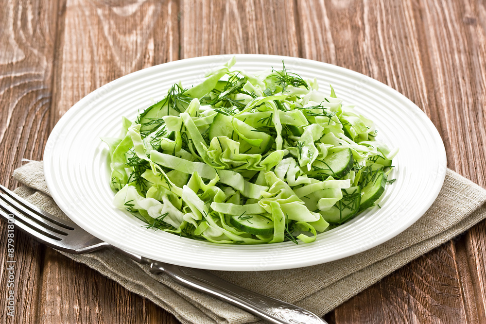 Cabbage cucumber salad / Cabbage cucumber salad with dill on rustic wooden background Cabbage cucumber salad / Cabbage cucumber salad with dill on rustic wooden background
