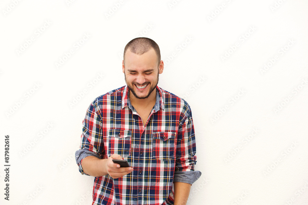 Man laughing after reading text on mobile phone Man laughing after reading text on mobile phone
