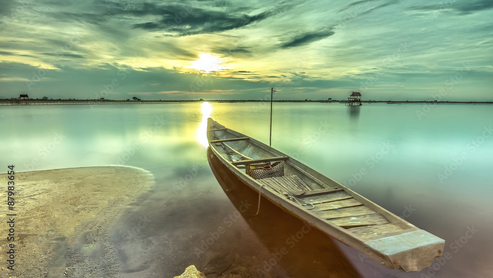 Sunset boat with the bow towards the sun is radiating rays horizon pave the dive location. Smooth water surface gives very peaceful setting in the countryside Hue