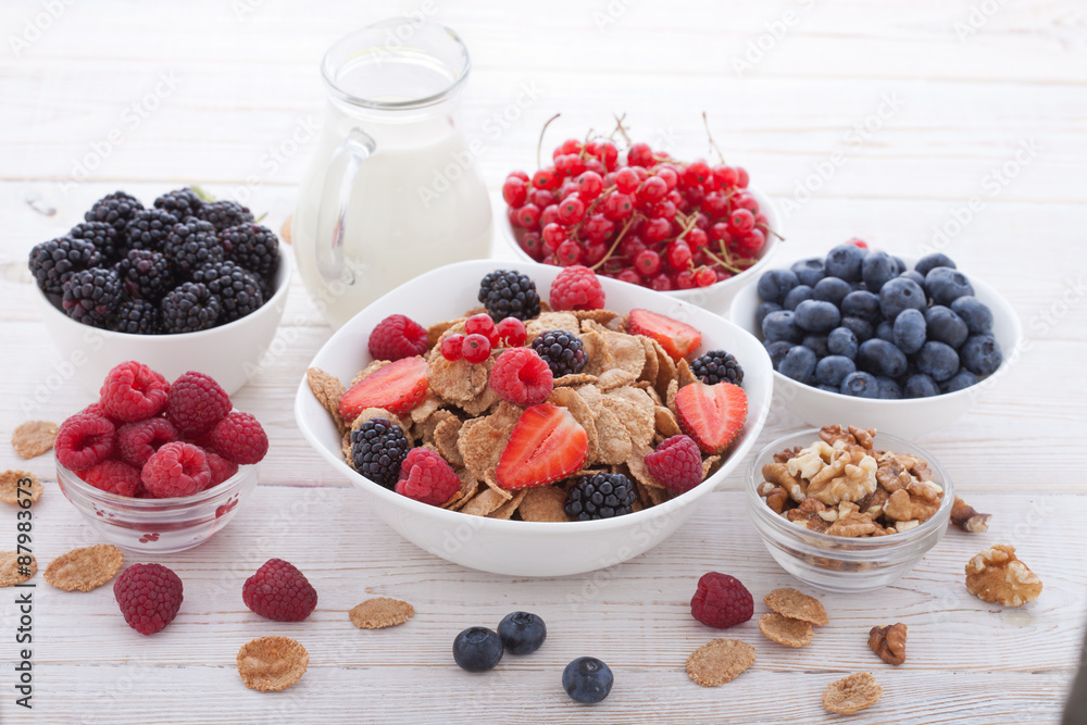 Breakfast - berries, fruit and muesli on white wooden Breakfast - berries, fruit and muesli on white wooden