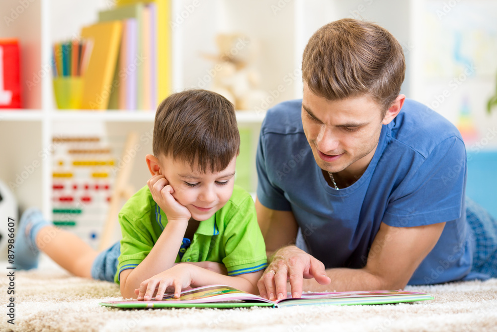 little boy and his dad read book together little boy and his dad read book together