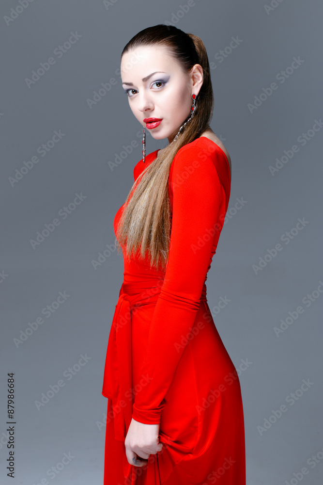 Fototapeta premium Beautiful female model posing in red dress