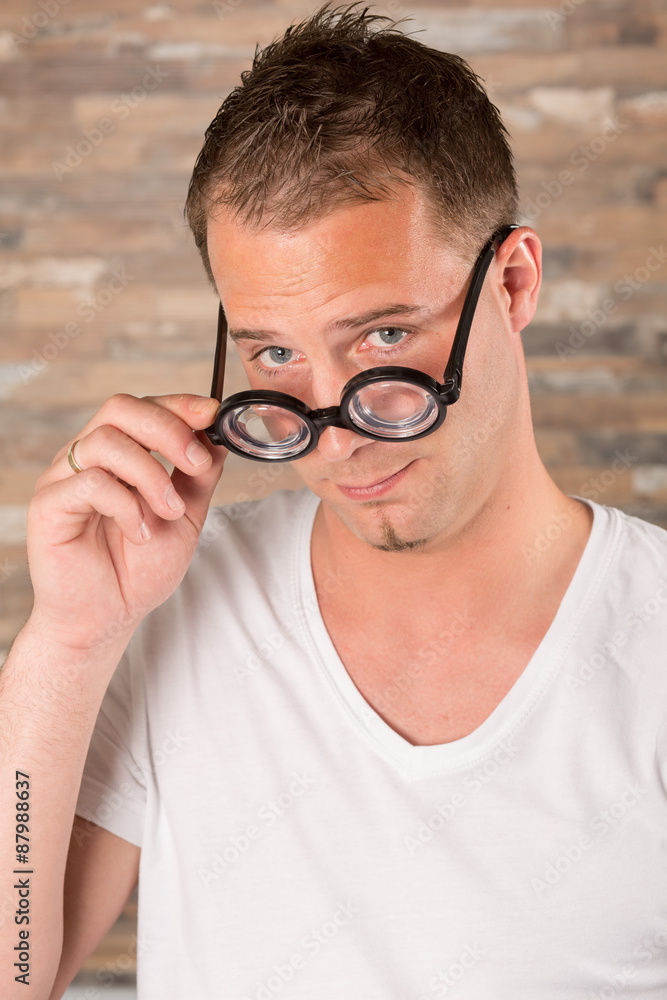 Junger Mann mit dicker Brille macht Grimassen / albern, fröhlich, spaßig –  Stock-Foto | Adobe Stock