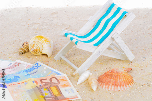 Strandstuhl auf Sand mit Geldscheinen