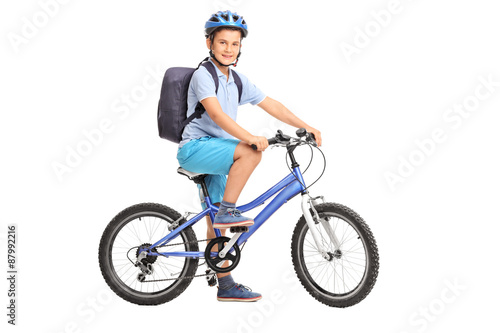 Studio shot of a schoolboy riding a bicycle