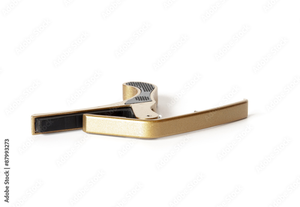 Golden metal guitar Capo isolated on white Golden metal guitar Capo isolated on white