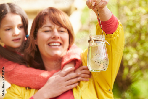 Mother And Daughter Looking At Frogspawn In Jar