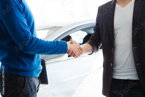 Good deal. Close-up shoot of hands shaking front  car