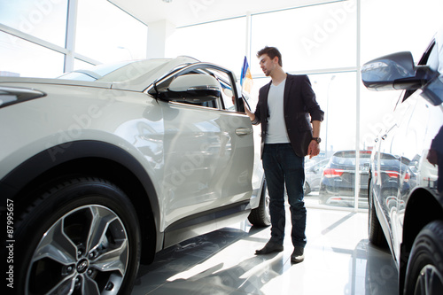 Man looking at new car in showroom