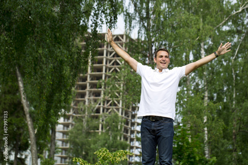 Happy Young handsome man on the background of summer street