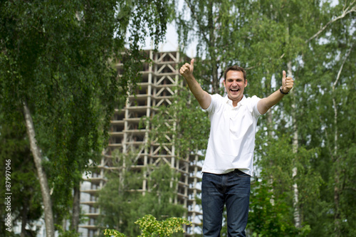 Happy Young handsome man on the background of summer street © Andrey_Arkusha