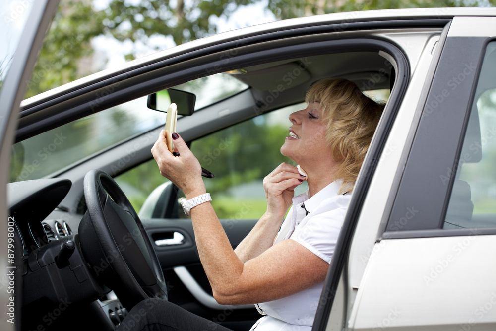 Old happy elderly driver woman 55-60 years in jacket Driving a C